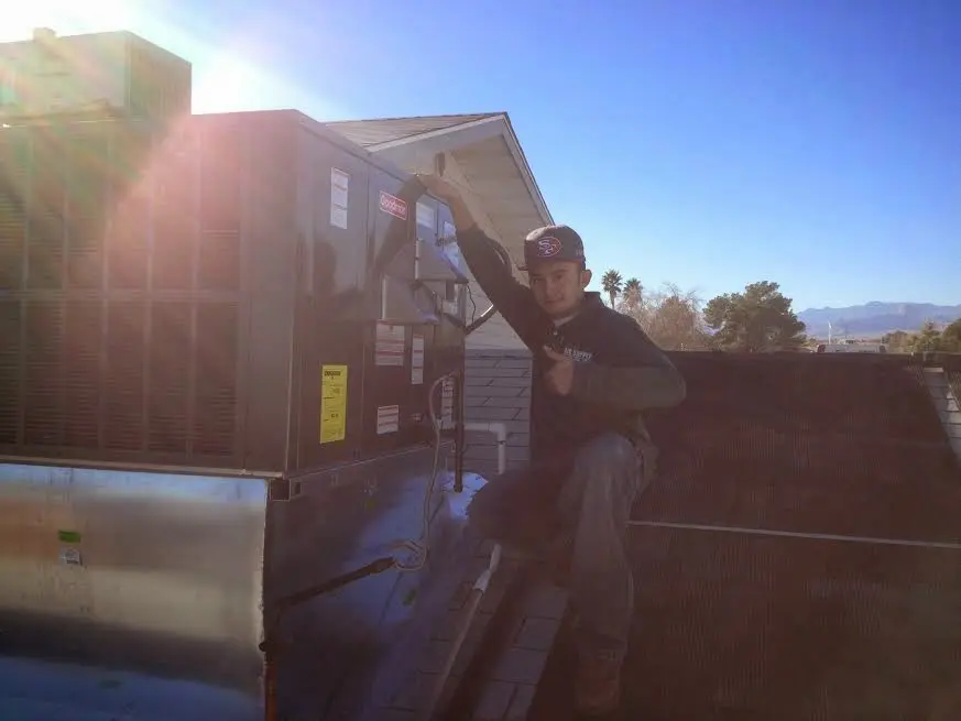 HVAC technician performing AC Tune-Up on a rooftop unit in Penn